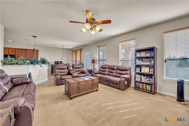 living room with light colored carpet and ceiling fan