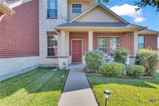 view of exterior entry featuring a yard