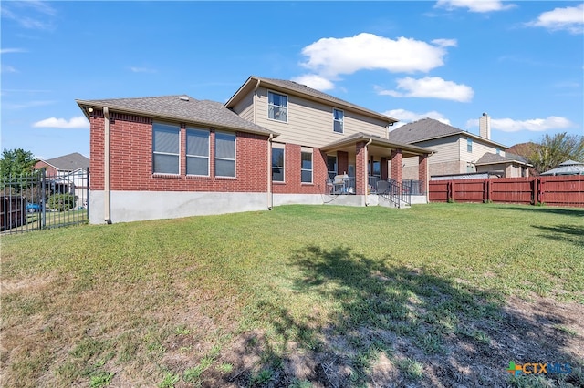 rear view of property featuring a yard