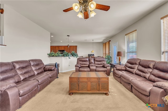 carpeted living room with ceiling fan