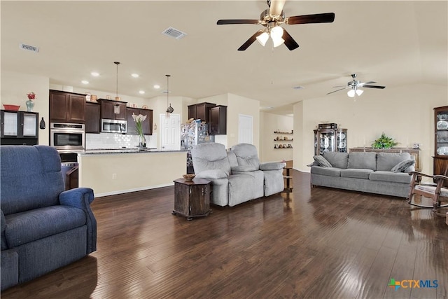 living room featuring dark wood-type flooring and ceiling fan