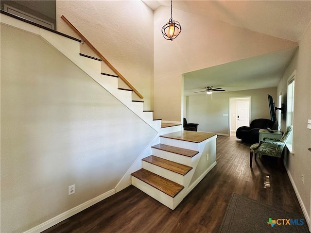 stairs featuring ceiling fan, high vaulted ceiling, and wood-type flooring