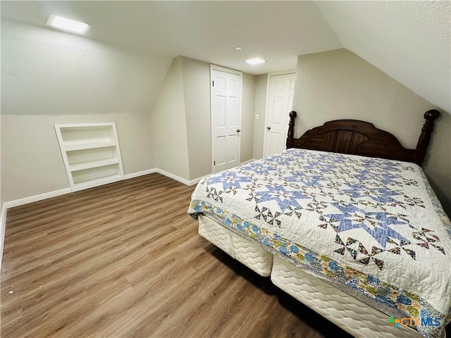 bedroom with a closet, vaulted ceiling, and hardwood / wood-style flooring