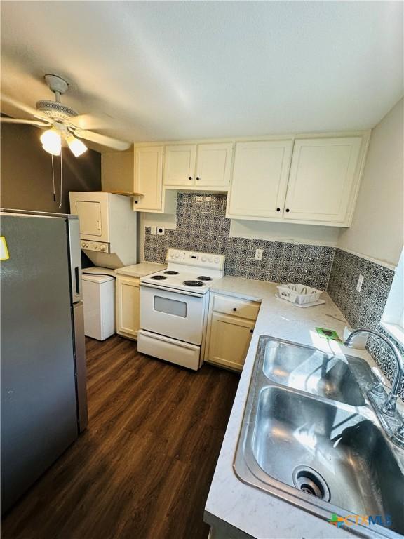 kitchen with sink, electric range, dark hardwood / wood-style floors, ceiling fan, and stainless steel refrigerator