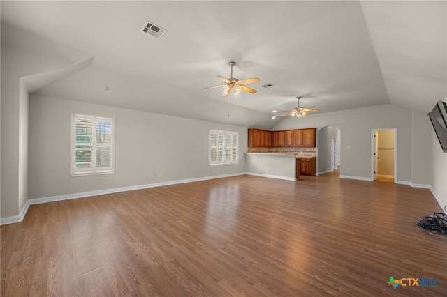 1018 Canyon Maple Rd, Pflugerville, TX 78660 - unfurnished living room featuring healthy amount of natural light, vaulted ceiling, ceiling fan, arched walkways, and wood finished floors