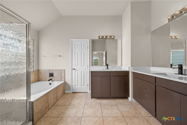 1018 Canyon Maple Rd, Pflugerville, TX 78660 - full bathroom with two vanities, a bath, tile patterned flooring, vaulted ceiling, and a shower stall