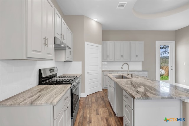 kitchen with white cabinets, stainless steel range with gas stovetop, sink, and dark hardwood / wood-style floors