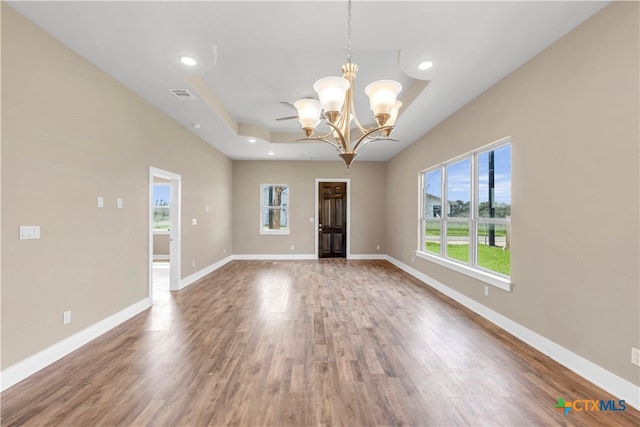 unfurnished room with wood-type flooring and a notable chandelier