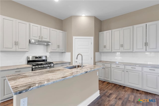 kitchen featuring a center island with sink, stainless steel gas stove, and white cabinetry