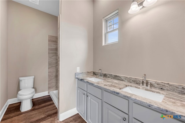 bathroom featuring walk in shower, wood-type flooring, vanity, and toilet