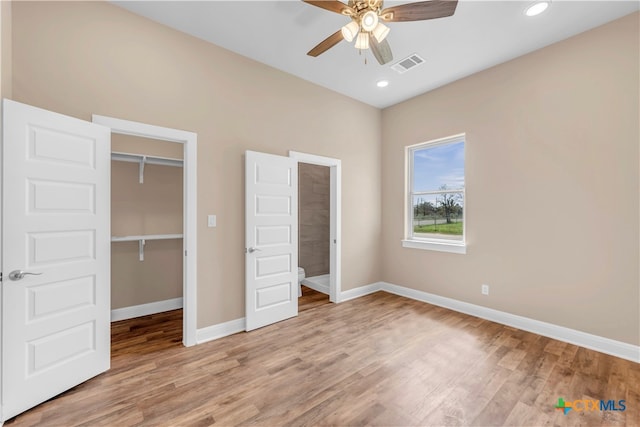 unfurnished bedroom featuring light hardwood / wood-style floors, ceiling fan, and a closet