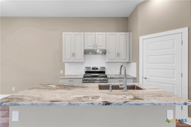 kitchen featuring light stone counters, white cabinetry, sink, hardwood / wood-style flooring, and stainless steel range with gas stovetop