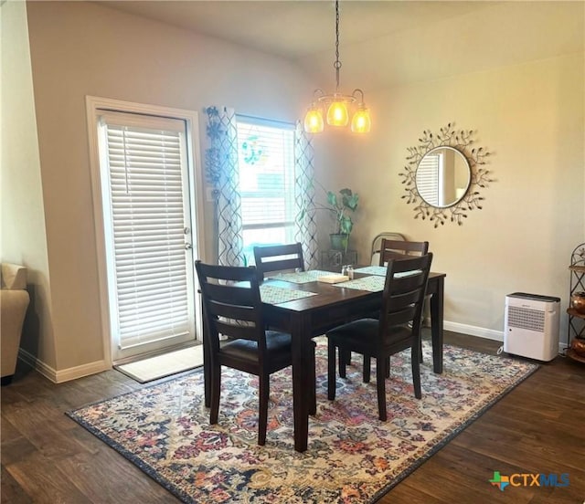 dining room with dark wood-type flooring and a notable chandelier