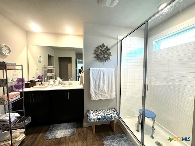 bathroom with a shower with door, vanity, and wood-type flooring