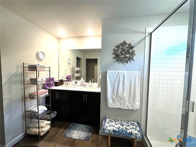 bathroom with hardwood / wood-style floors, vanity, and a shower with door