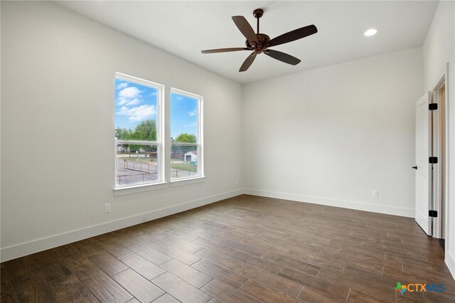 spare room featuring recessed lighting, baseboards, a ceiling fan, and dark wood finished floors
