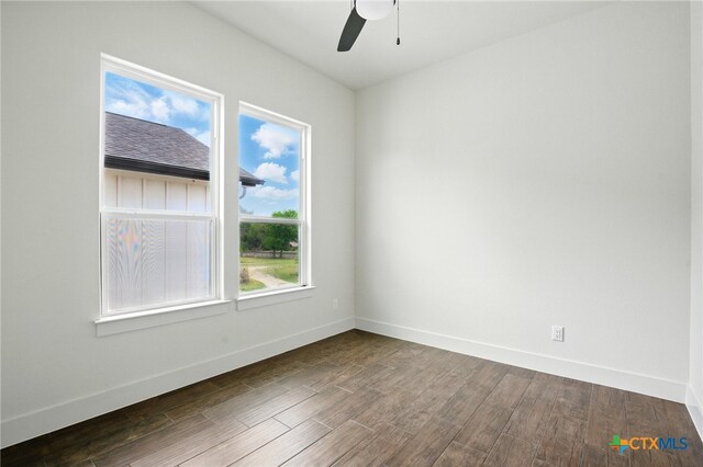 unfurnished room with baseboards, a ceiling fan, and dark wood-type flooring