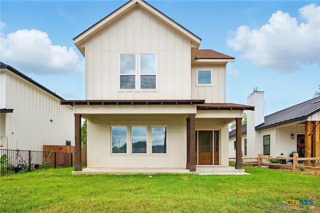 back of house featuring board and batten siding, brick siding, and fence