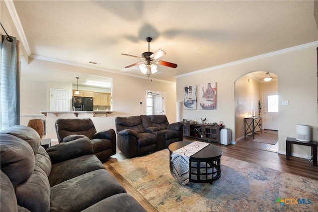 living room with hardwood / wood-style floors, ceiling fan, and ornamental molding