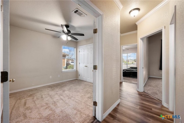 interior space with a wealth of natural light, crown molding, and hardwood / wood-style flooring