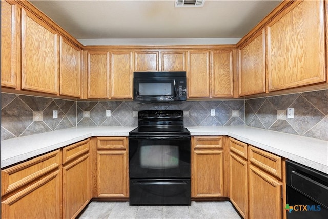 kitchen featuring light tile patterned floors, backsplash, and black appliances