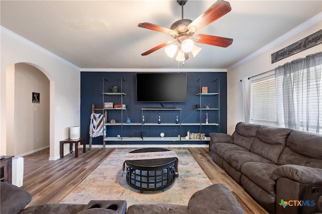 living room featuring hardwood / wood-style flooring, ceiling fan, and crown molding