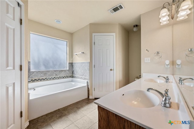 bathroom with a bathtub, vanity, a chandelier, and tile patterned flooring