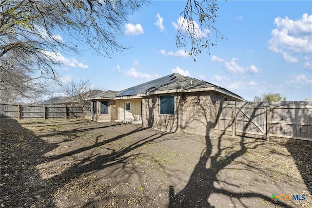 back of house featuring solar panels