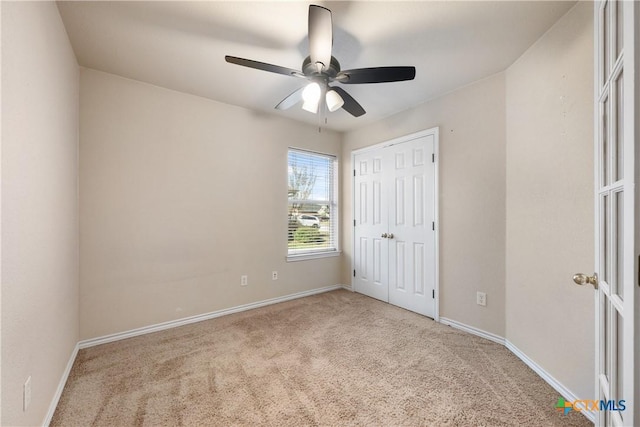 unfurnished bedroom with ceiling fan, a closet, and light colored carpet