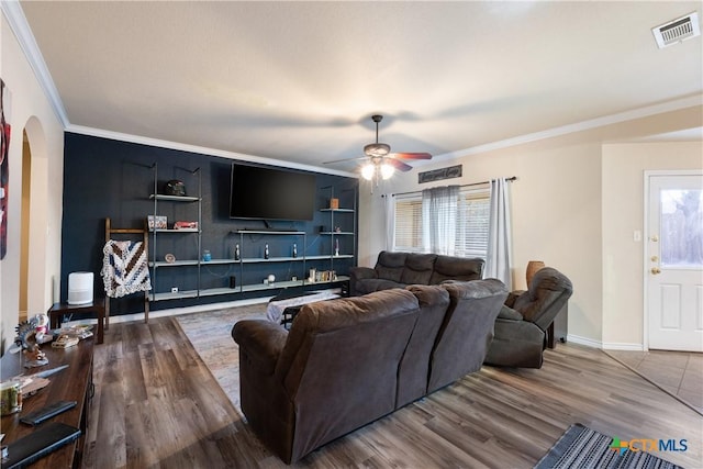 living room featuring hardwood / wood-style floors, a wealth of natural light, and crown molding