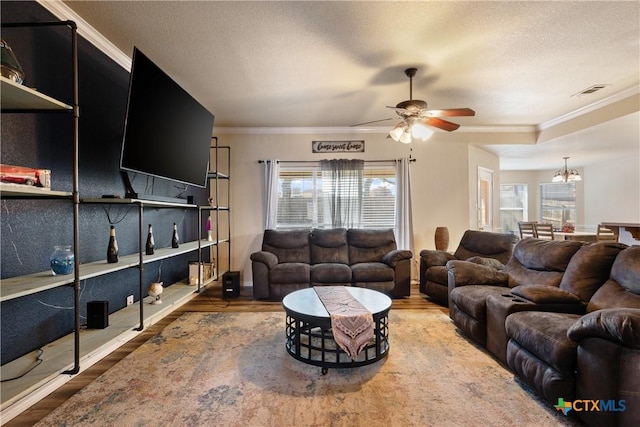 living room featuring a textured ceiling, crown molding, wood-type flooring, and ceiling fan with notable chandelier