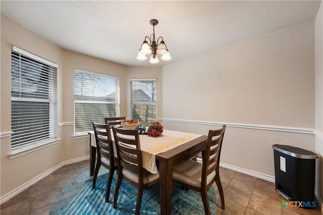 dining area with a notable chandelier and dark tile patterned floors