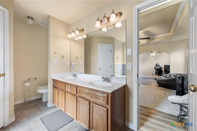 bathroom featuring ceiling fan, vanity, wood-type flooring, and toilet