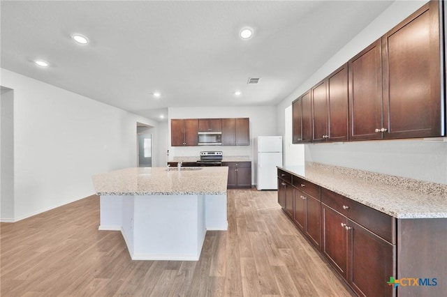 813 Indigo Way, Seguin, TX 78155 - kitchen featuring stainless steel appliances, a sink, light wood-style flooring, light stone counters, and recessed lighting