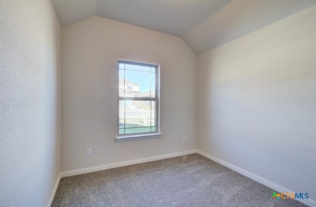 empty room featuring carpet flooring and lofted ceiling