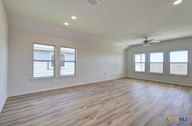 spare room with vaulted ceiling, light hardwood / wood-style flooring, and ceiling fan