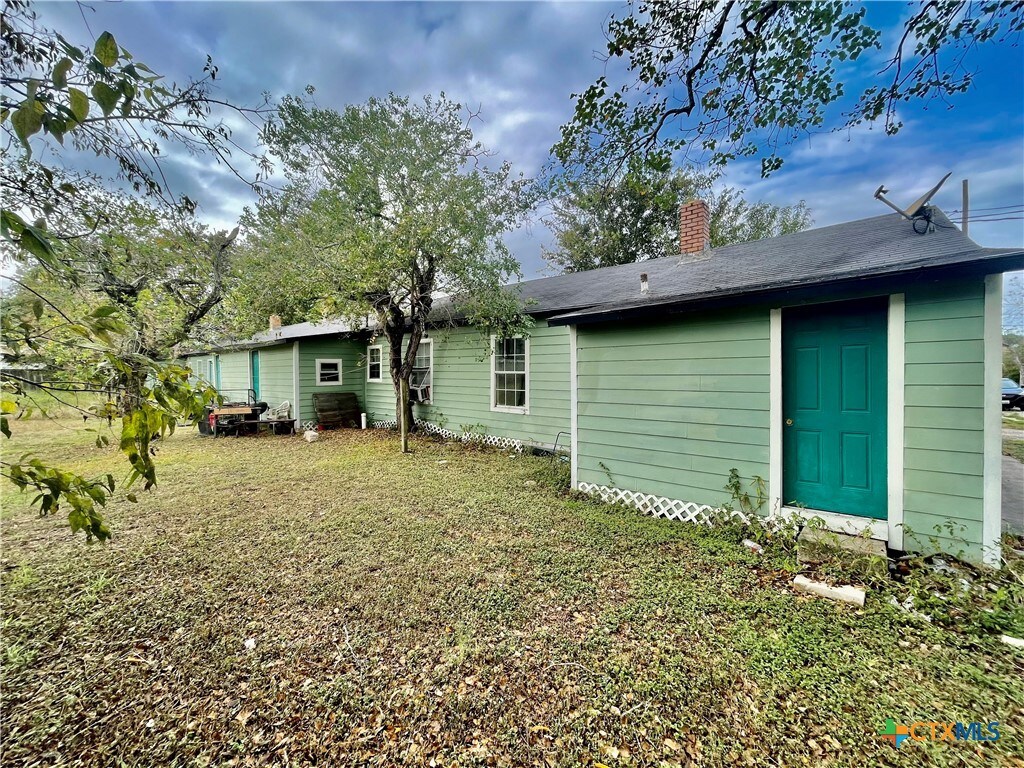 rear view of property featuring a lawn