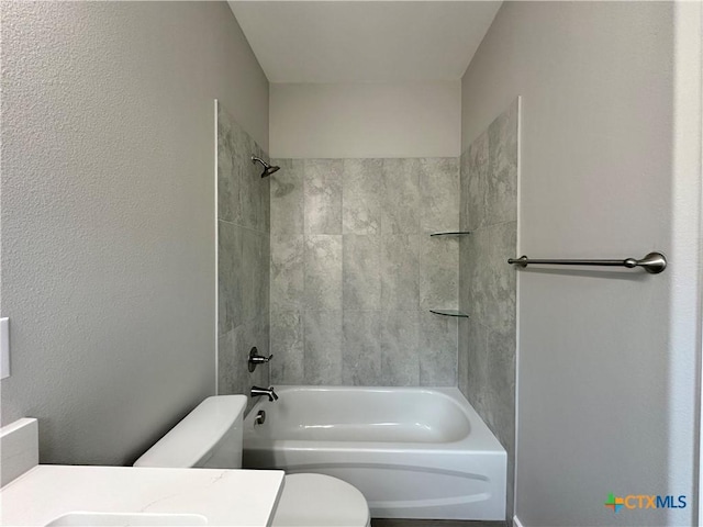 bathroom with toilet and tiled shower / bath