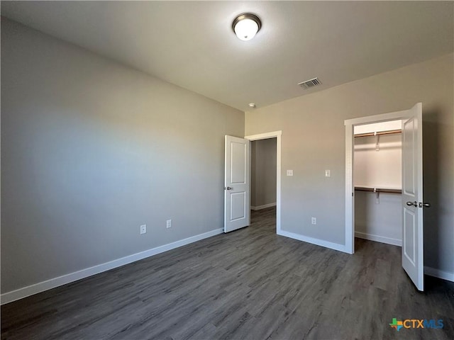 unfurnished bedroom with hardwood / wood-style flooring and a closet