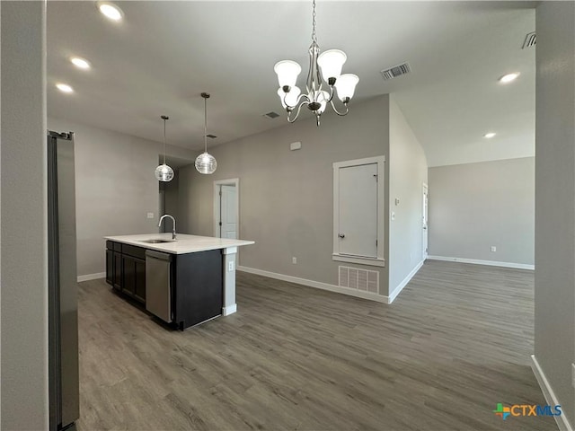 kitchen featuring an island with sink, sink, hanging light fixtures, hardwood / wood-style flooring, and stainless steel appliances