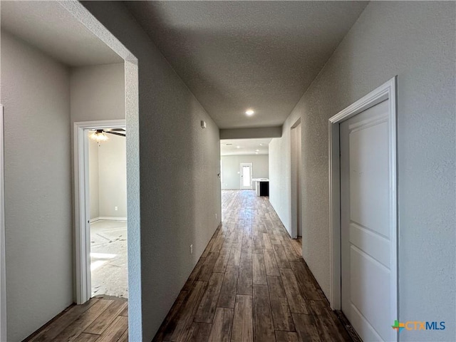 hall featuring hardwood / wood-style floors and a textured ceiling