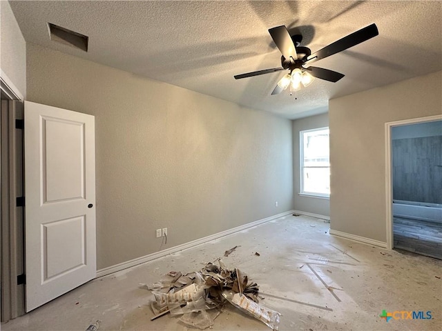 unfurnished room with ceiling fan and a textured ceiling