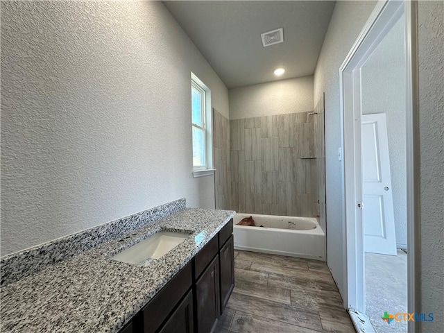 bathroom with vanity and tiled shower / bath