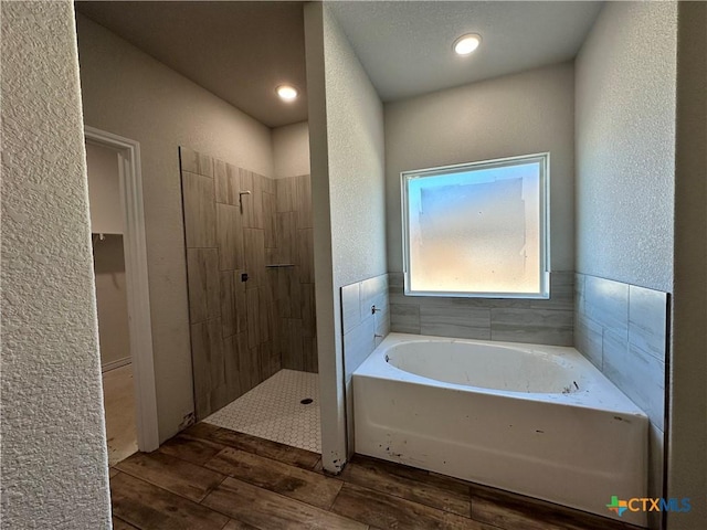 bathroom featuring hardwood / wood-style flooring and shower with separate bathtub