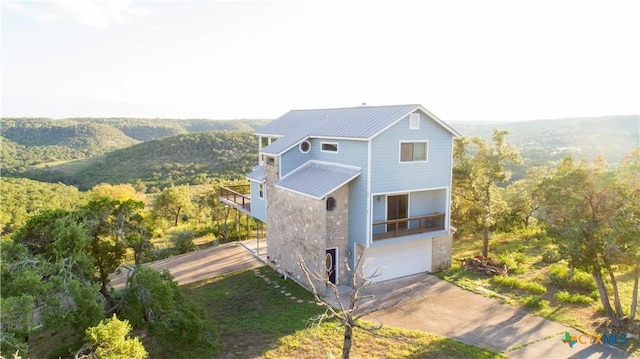 461 Naked Indian Trl, New Braunfels, TX 78132 - view of side of property with a balcony, metal roof, driveway, and a view of trees
