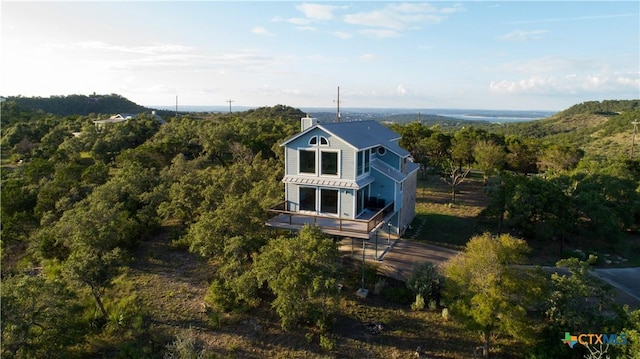 461 Naked Indian Trl, New Braunfels, TX 78132 - rear view of house featuring a chimney, a view of trees, a wooden deck, and a balcony