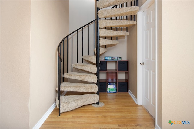 staircase with hardwood / wood-style flooring