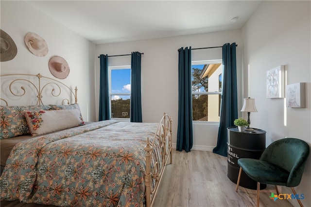 bedroom with light wood-type flooring and multiple windows