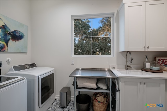 laundry room with cabinets, sink, and washer and dryer