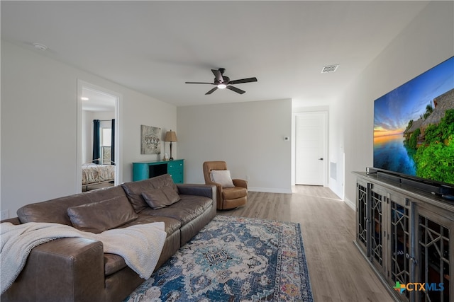 living room with ceiling fan and light hardwood / wood-style floors